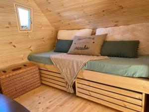 a bedroom with two beds in a log cabin at Cabane Forest in Villaines-la-Gonais
