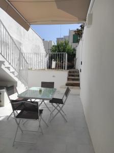 a patio with a glass table and chairs at Dimora Collina 3 in Sannicola