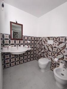 a bathroom with a sink and a toilet and a mirror at Dimora Collina 3 in Sannicola