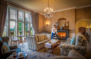 a woman standing in a living room with a fireplace at Lough Rynn Castle in Mohill
