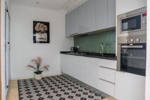 a kitchen with white cabinets and a checkered floor at Appartement Chanel in Assomada