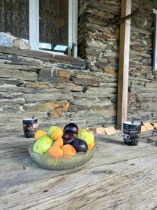 a bowl of fruit sitting on a wooden deck at Guesthouse Lika in Ushguli