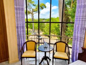a room with two chairs and a table in front of a window at Hung Vuong Hotel in Ben Tre