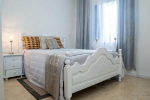 a white bed in a bedroom with a window at Appartement Chanel in Assomada