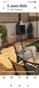 a table and chairs in a room with a piano at casa Montoro in Purchil