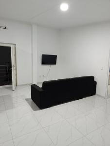 a black couch in a white room with a tv at Apartamento Cidadela in Praia