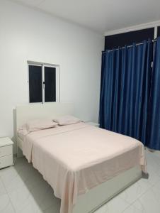 a bedroom with two beds and blue curtains at Apartamento Cidadela in Praia