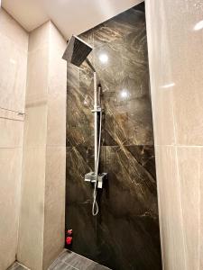 a shower in a bathroom with a stone wall at LalaHouse Pasteur in Ho Chi Minh City +58 photos