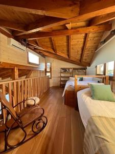 a bedroom with two beds and a chair in a cabin at Luxury Rural Cuenca - Villas in Cuenca