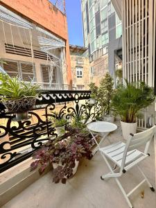 a balcony with a table and chairs and potted plants at LalaHouse Pasteur in Ho Chi Minh City