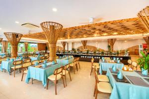 a restaurant with blue tables and chairs and a bar at Silver Beach Resort Ke Ga in Ke Ga +78 photos