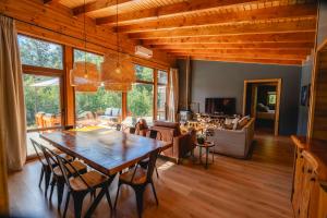 a dining room and living room with a table and chairs at Peuma Lodge Patagonia in Futaleufú