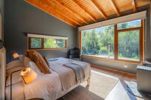 a bedroom with a bed and a large window at Peuma Lodge Patagonia in Futaleufú +74 photos