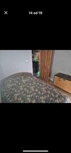 a bedroom with a bed with a floral bedspread at Chill & Woods in Štrucljevo