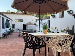 a table and chairs with an umbrella on a patio at Puerta del Agua in Uclés