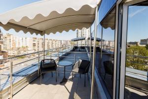 a balcony with a table and chairs on a building at Boutique Spa Casino Hotel Lybid Plaza in Khmelnytskyi