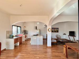 a large kitchen with white walls and wooden floors at Villa Soafeno in Antsiranana