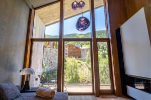 a living room with a large window with a view at Isard Penthouse & Spa in El Tarter