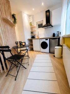 a kitchen with a table and chairs in a room at Le Goldorak, Hyper-centre, Garage privé, CLIM et canal plus in Niort