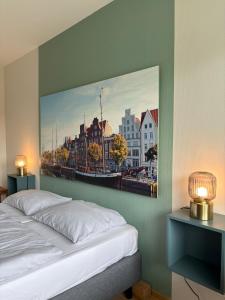 a bedroom with a large painting of a city at Hotel Am Mühlenteich in Lübeck