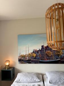a room with two beds and a painting of a harbor at Hotel Am Mühlenteich in Lübeck
