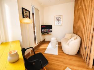 a living room with a white couch and a chair at Le Goldorak, Hyper-centre, Garage privé, CLIM et canal plus in Niort