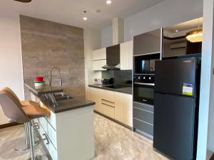 a kitchen with a black refrigerator and a sink at High Class 1BR at One Euphoria in Angeles