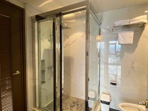 a glass shower in a bathroom with a sink at High Class 1BR at One Euphoria in Angeles +71 photos
