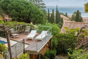 a wooden deck with a view of the ocean at Villa Les Dauphins in Le Lavandou