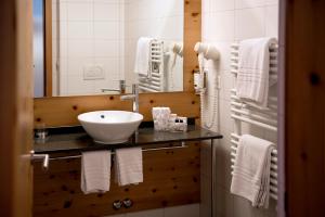 a bathroom with a sink and a mirror and towels at 3100 Kulmhotel Gornergrat in Zermatt +31 photos