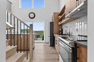a kitchen with wooden cabinets and a clock on the wall at Apex Nuage - Spa Game Room & Panoramic Views in Saint Come