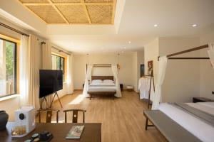 a bedroom with a bed and a tv in a room at Dunhuang County Posthouse in Dunhuang +31 photos