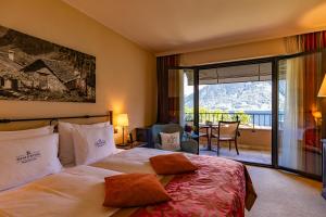 a hotel room with a bed and a balcony at Boutique-Hotel REMORINO, a Lago Maggiore GARDEN RESORT in Locarno