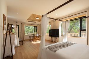 a bedroom with a bed and a television in it at Dunhuang County Posthouse in Dunhuang