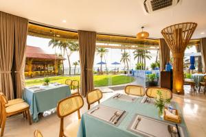 a dining room with a table and chairs and a patio at Silver Beach Resort Ke Ga in Ke Ga