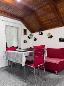 a living room with red chairs and a table at Ravne Konak in Visoko