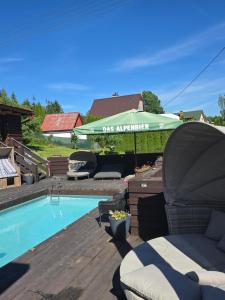a patio with an umbrella and a swimming pool at Beskydy Areal in Prostřední Bečva