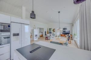 a kitchen with white appliances and a living room at Villa Vilkama 2 cabins Lake view, incl indoor hot tub, sauna in Laukaa