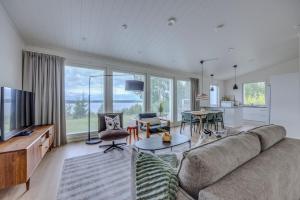 a living room with a large couch and a table at Villa Vilkama 2 cabins Lake view, incl indoor hot tub, sauna in Laukaa