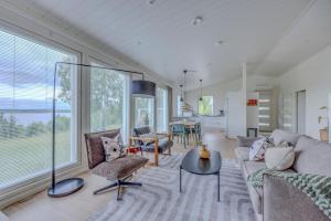 a living room with a couch and chairs and a table at Villa Vilkama 2 cabins Lake view, incl indoor hot tub, sauna in Laukaa
