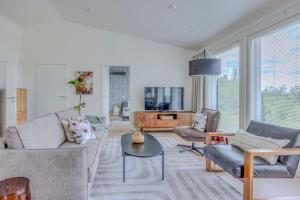 a living room with a couch and chairs and a table at Villa Vilkama 2 cabins Lake view, incl indoor hot tub, sauna in Laukaa