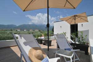 a patio with two chairs and an umbrella at Liostasi Villas by Olga in Leptokarya