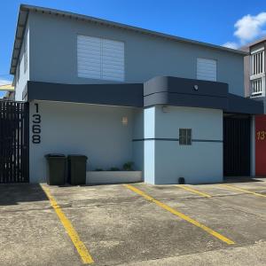 a blue and white building with a parking lot at OJAS Local Nest in San Juan
