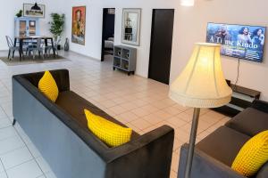 a living room with two couches and a lamp at OJAS Local Nest in San Juan