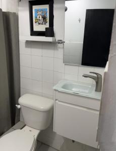 a white bathroom with a toilet and a sink at OJAS Local Nest in San Juan +8 photos