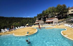 a swimming pool with a beach and people in the water at Soleiou in Salavas