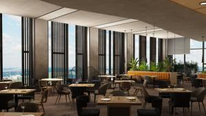 a restaurant with tables and chairs and large windows at Novotel Bhubaneswar Janpath in Bhubaneshwar