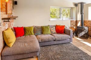 a brown couch with colorful pillows in a living room at Luxury Escape with Cinema, Pool Table & Darts in Leeds