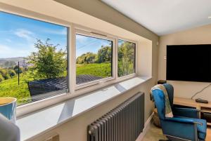 a room with two windows and a flat screen tv at Luxury Escape with Cinema, Pool Table & Darts in Leeds