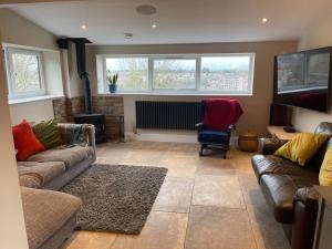 a living room with two couches and a fireplace at Luxury Escape with Cinema, Pool Table & Darts in Leeds